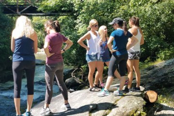 a group of people standing next to a river