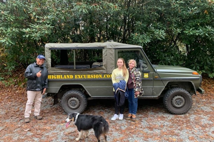 a group of people standing in front of a car