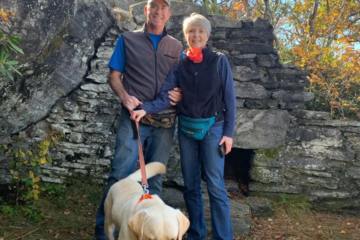 a man standing next to a dog on a leash