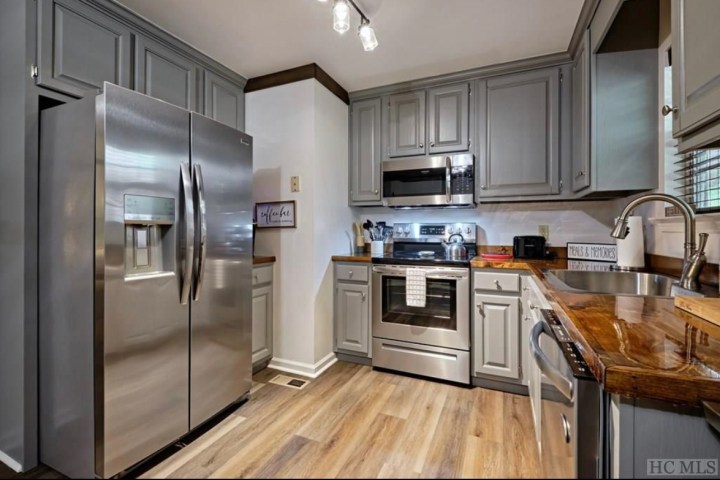 a modern kitchen with stainless steel appliances and wooden cabinets